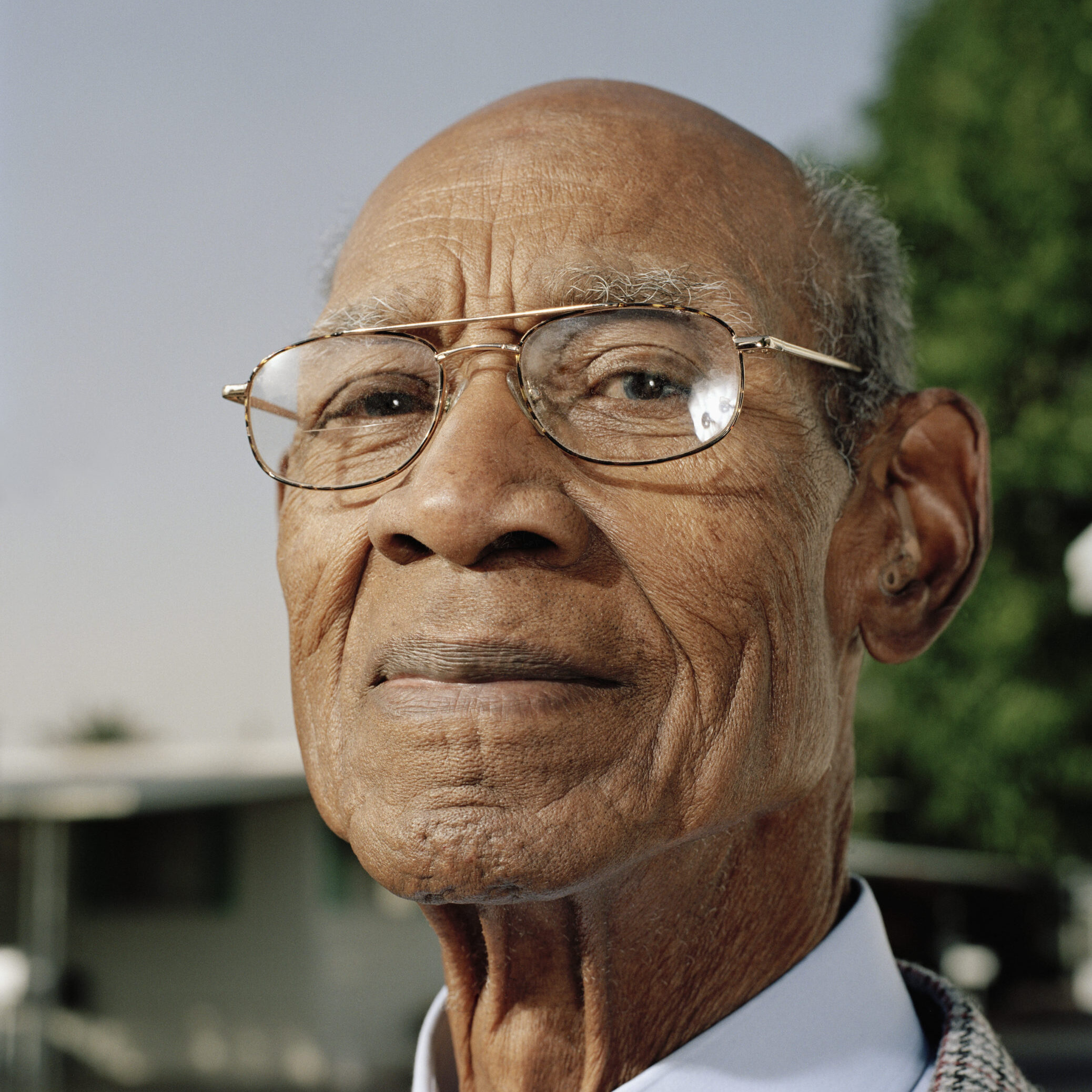 Senior man wearing glasses, smiling, portrait